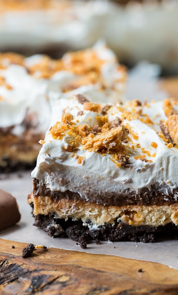 Butterfinger Chocolate Lush has an oreo cookie crumb bottom, a peanut butter layer with crushed butterfingers, an chocolate pudding layer, and a Cool Whip topping.