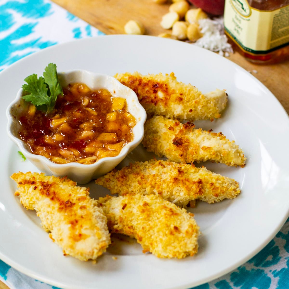 Coconut Macadamia Chicken Tenders on plate with peach red pepper jelly.