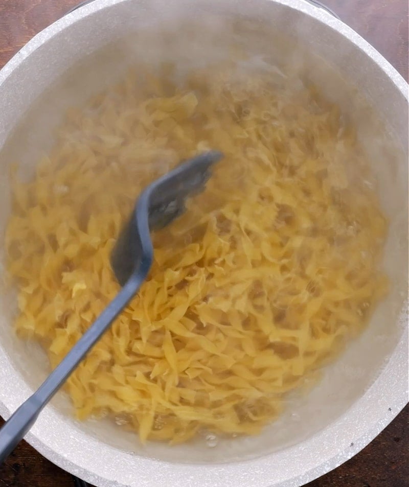 Noodles cooking in pot.