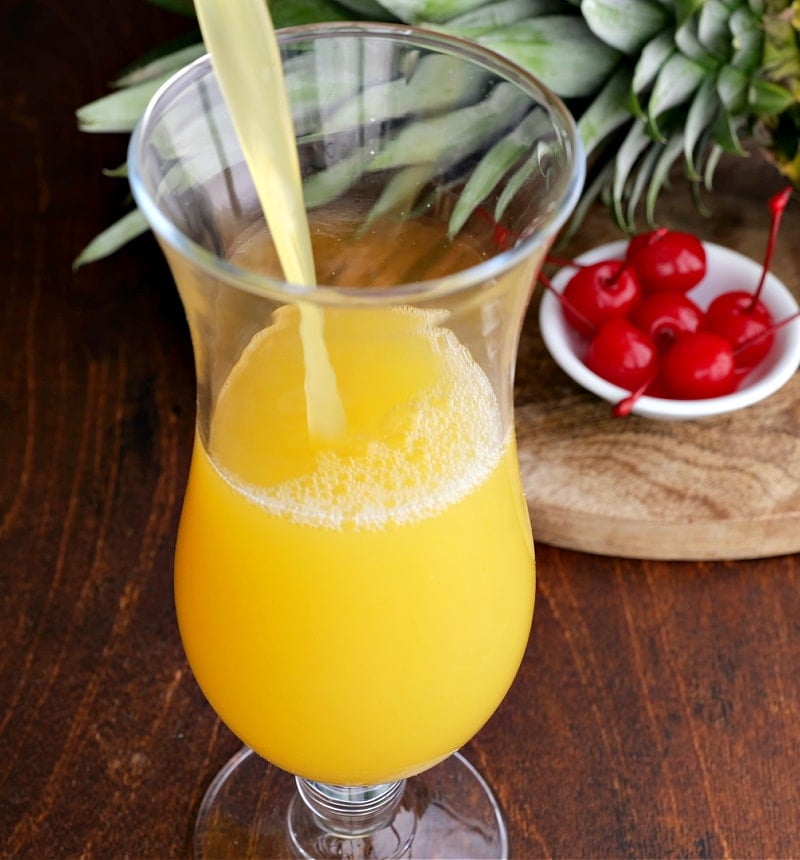 Pineapple mixture poured into hurricane glass.