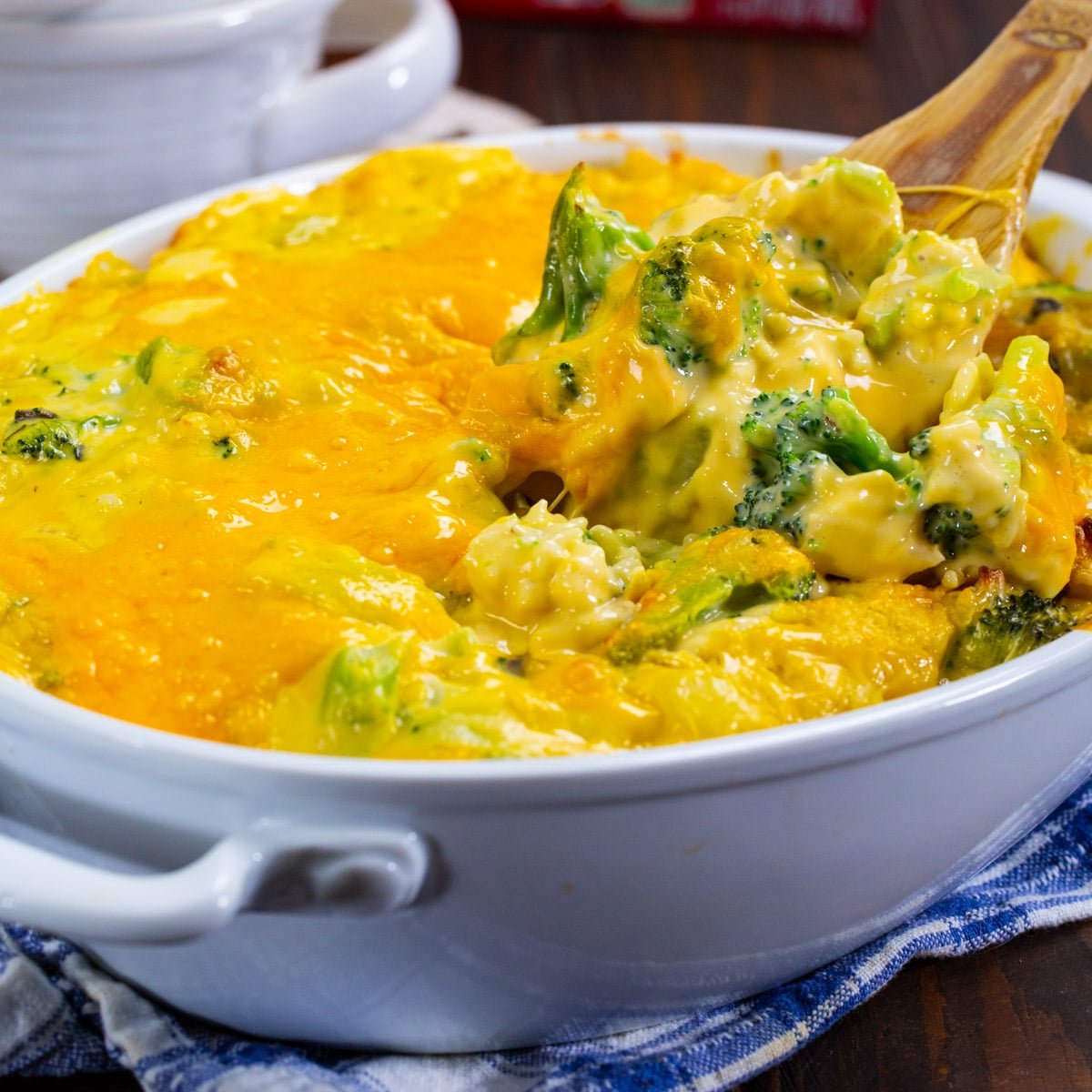 Wooden spoon scooping up Broccoli Rice Casserole.