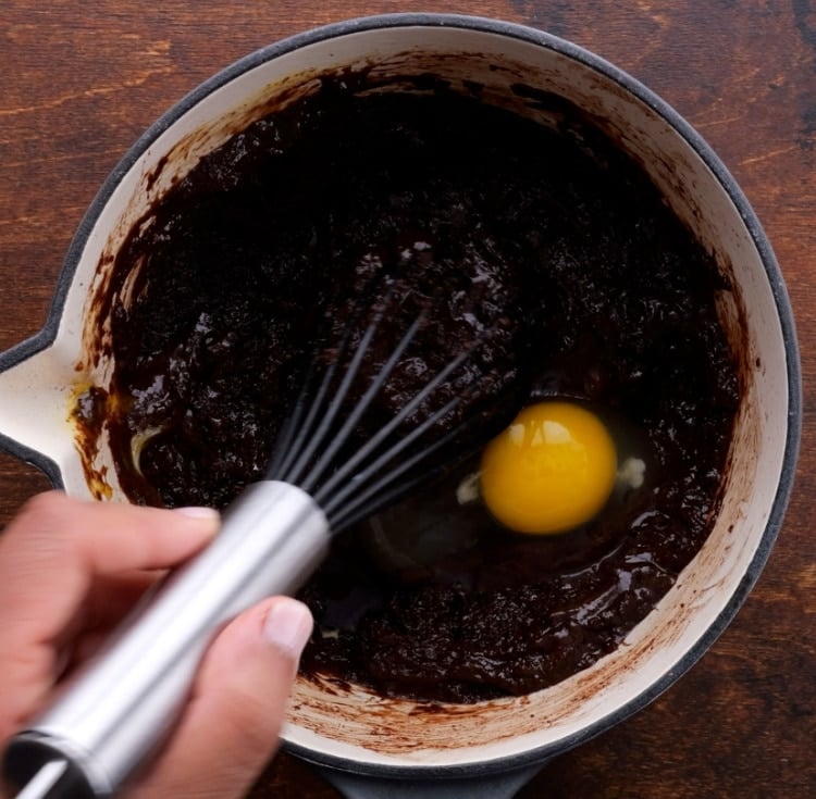 Mixing eggs into batter.