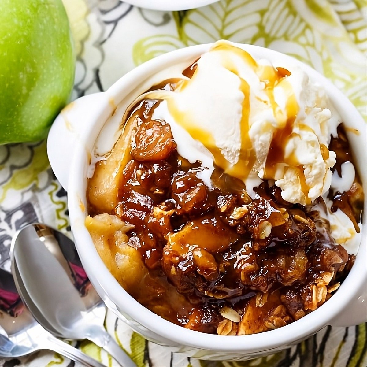 Butterscotch Apple Crisp topped with ise cream in a bowl.