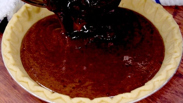 Pouring batter into pie crust.