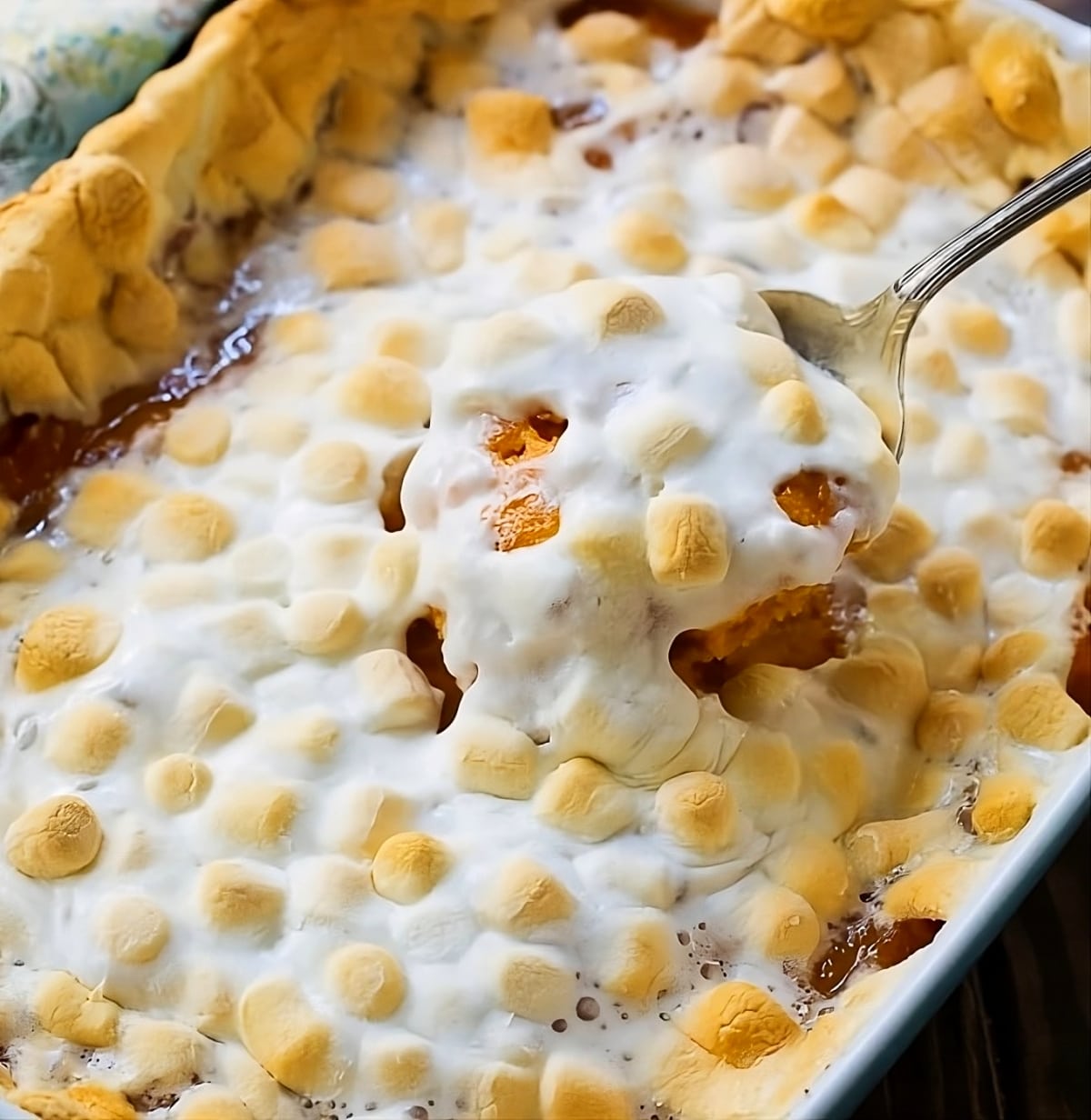 Spoon scooping sweet potato casserole out of baking dish.