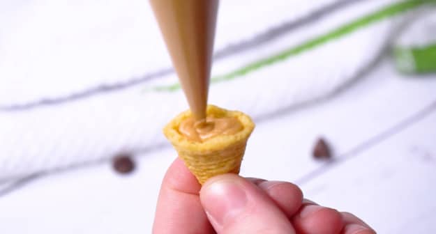 Filling bugle with peanut butter.