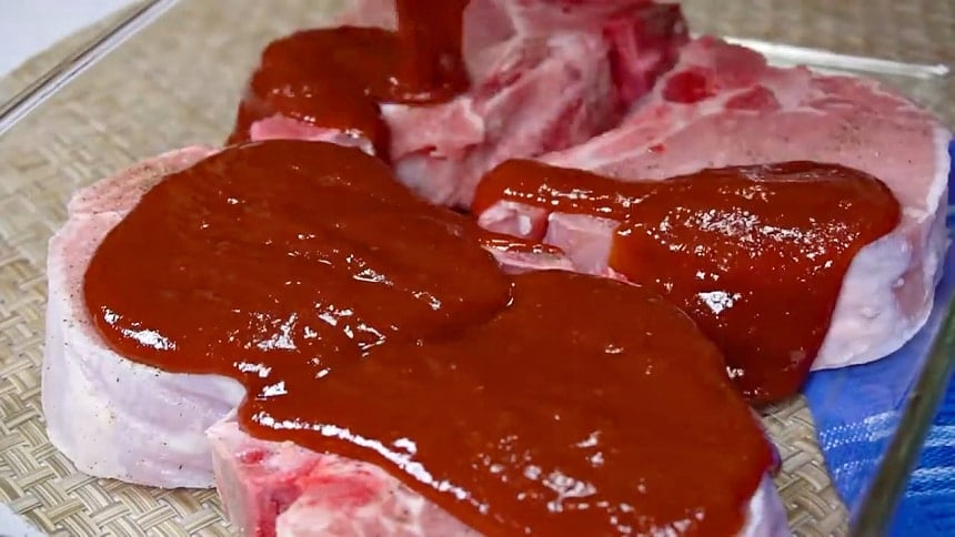 Pouring the sauce over pork chops.