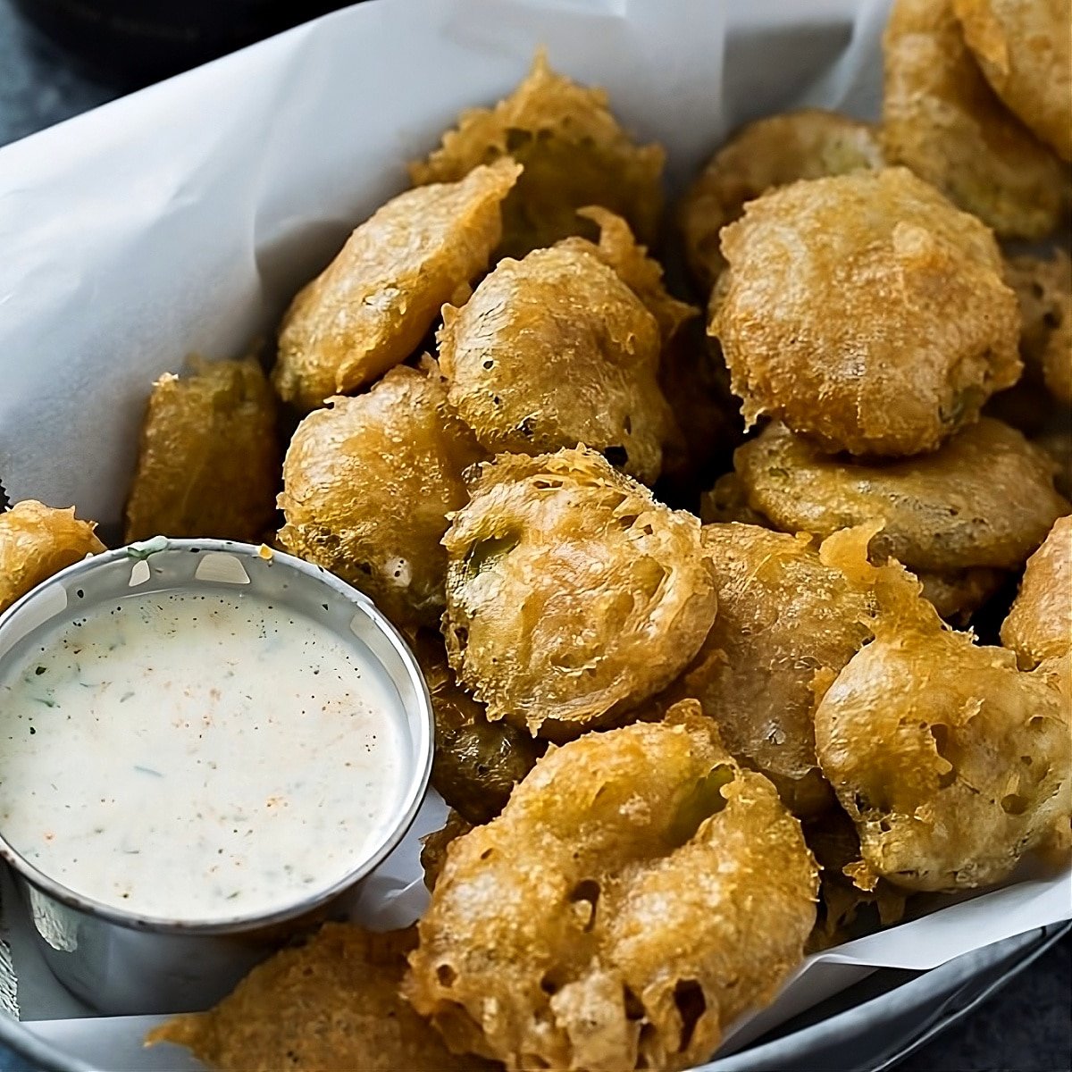 Fried Pickles in a tray with spicy ranch dipping sauce.