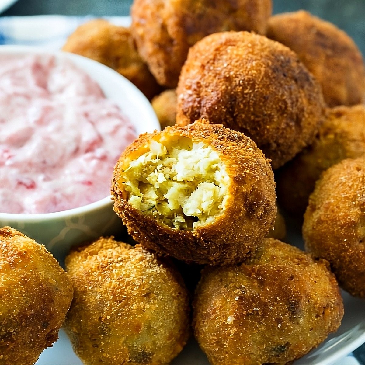 Deep-Fried Stuffing balls on a plate with cranberry sauce.