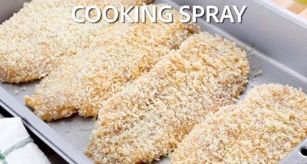 Spraying chicken with cooking spray.