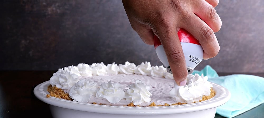 Decorating pie with whipped cream.