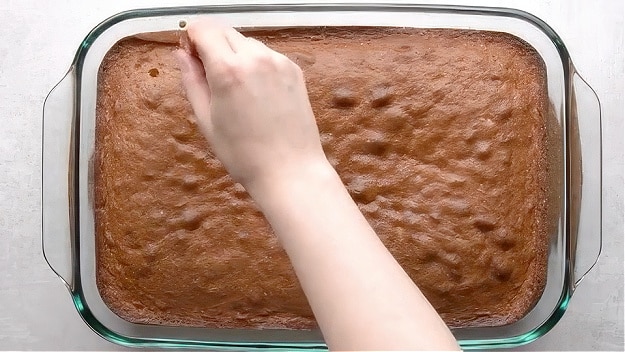 Poking holes in cake.