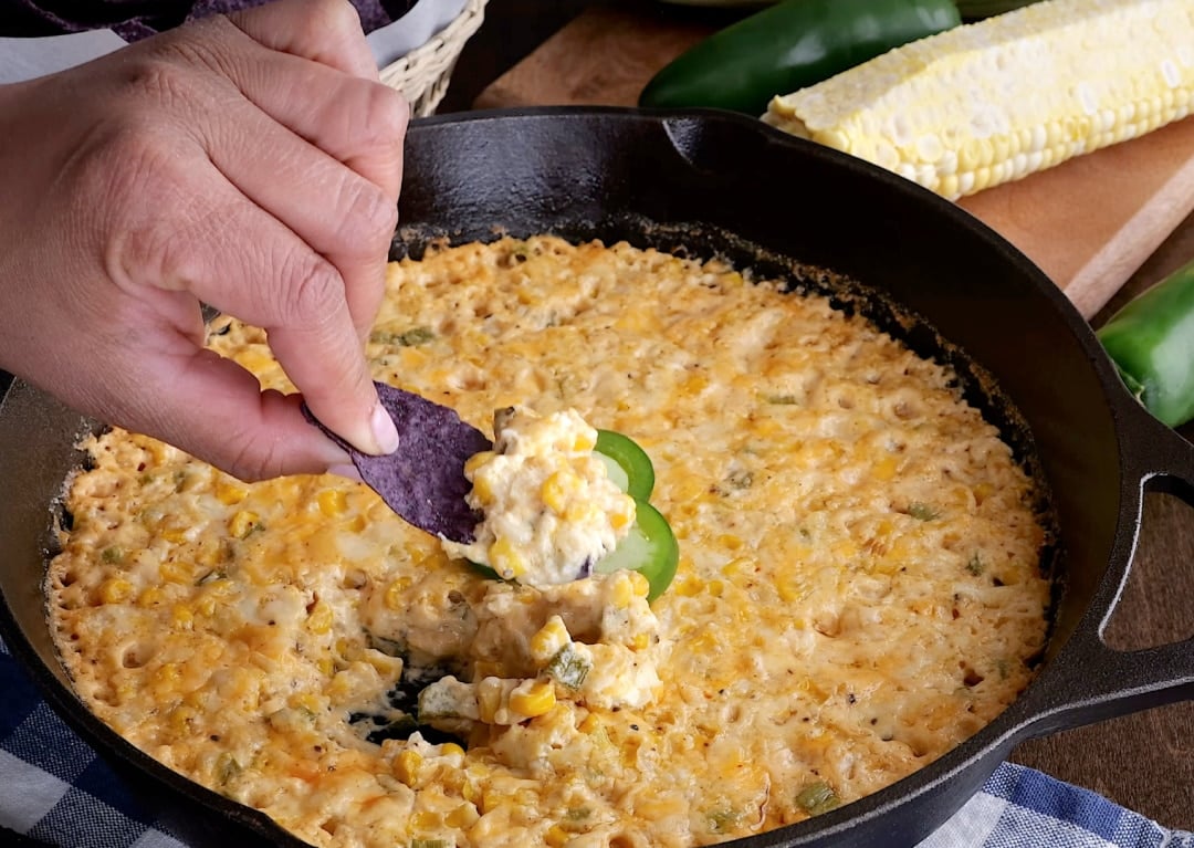 Chip dipping into spicy corn dip.
