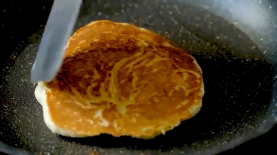 Cooking pancake in skillet.