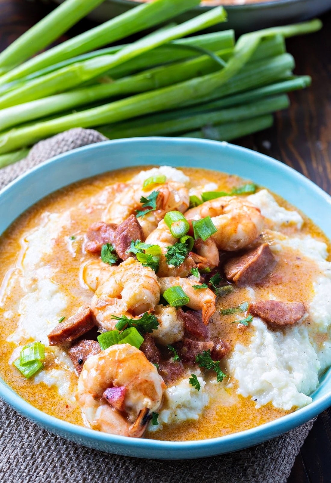 Smothered Shrimp and Parmesan Grits in a light blue bowl.