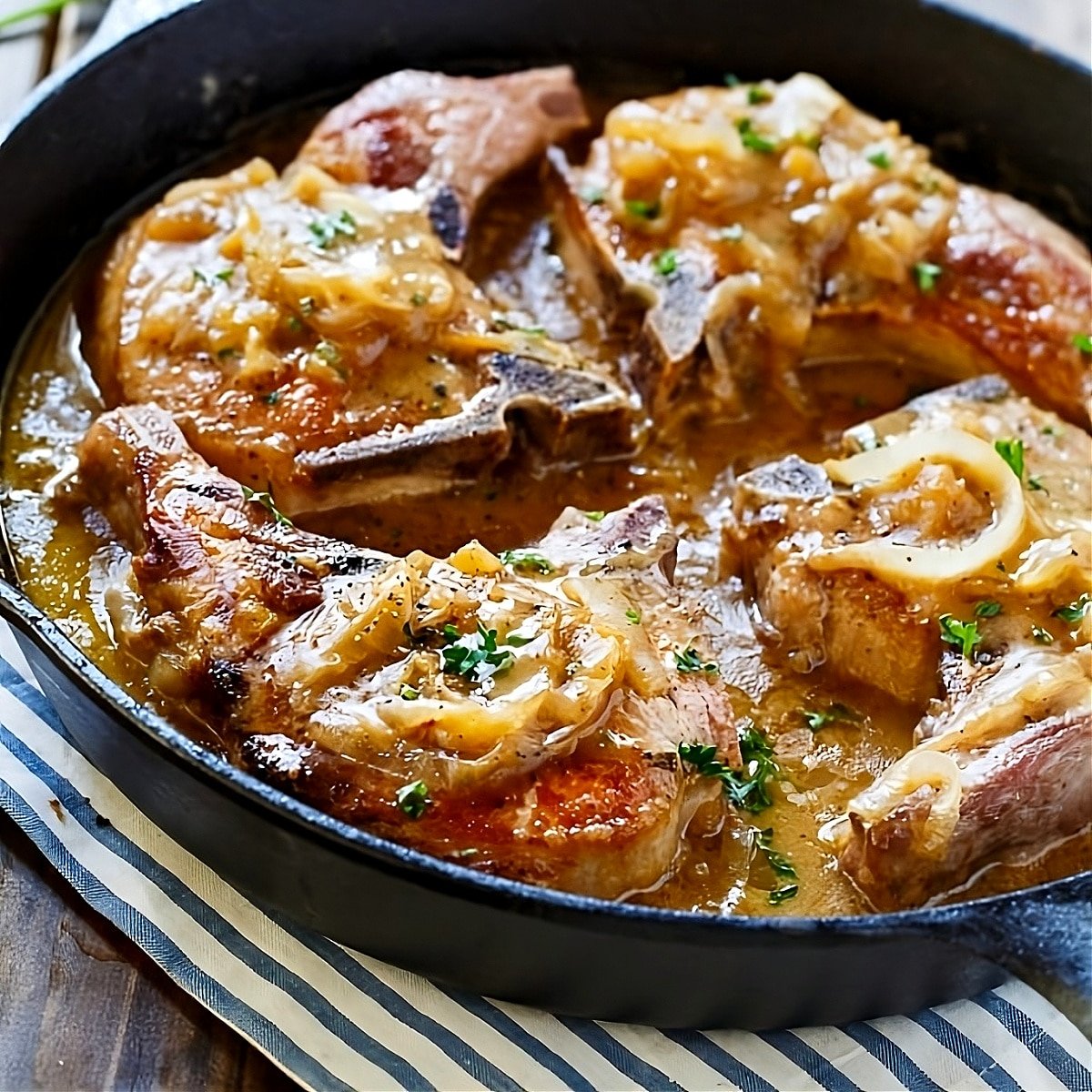 Smothered Southern Pork Chops in cast iron pan.