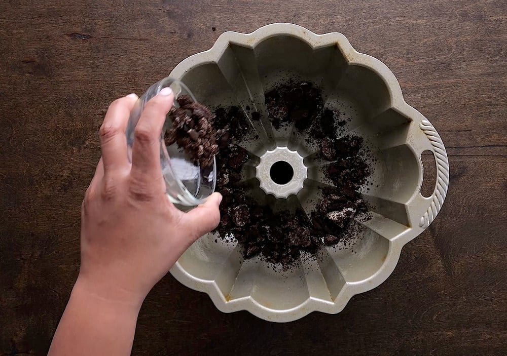 Oreo crumbs sprinkled into bundt pan.
