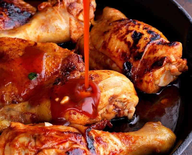 Pouring glaze on chicken.