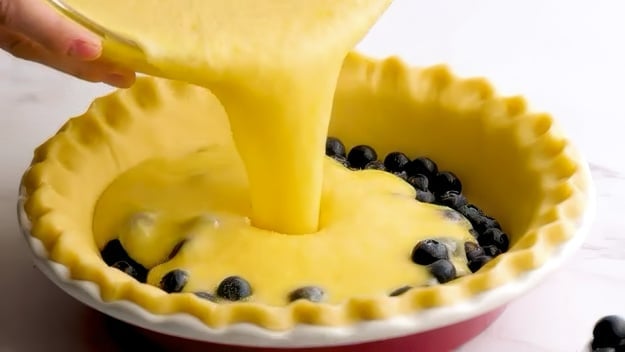 Pouring batter into crust.