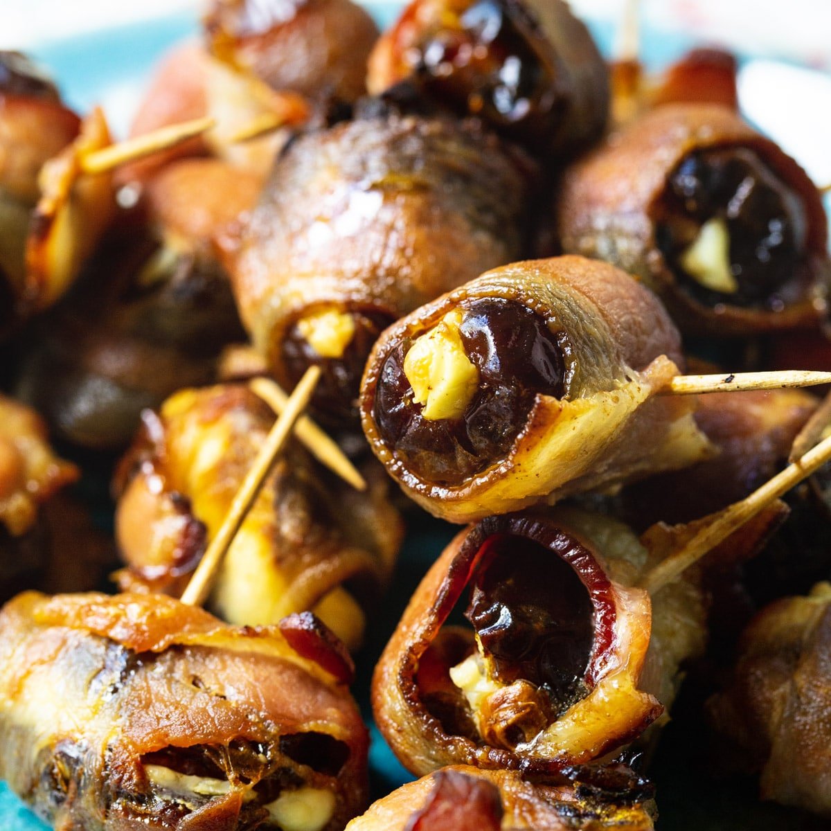 Bacon Wrapped Stuffed Dates with tooothpicks stuck in them.