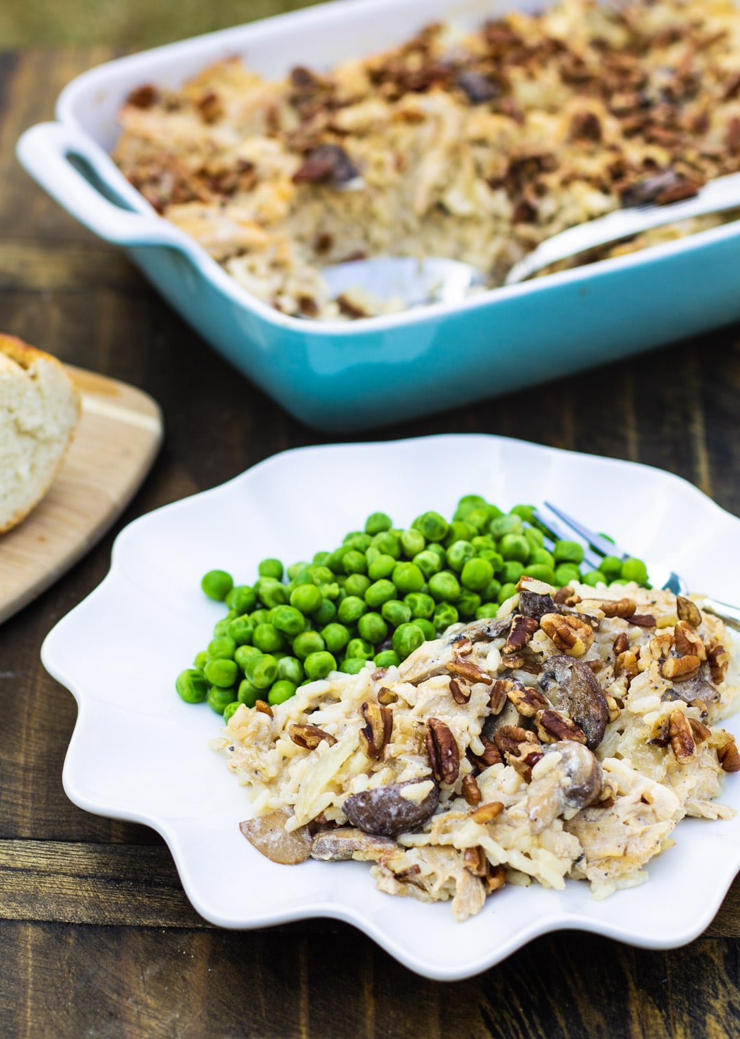 Casserole dished up on a plate with baking dish full of casserole.