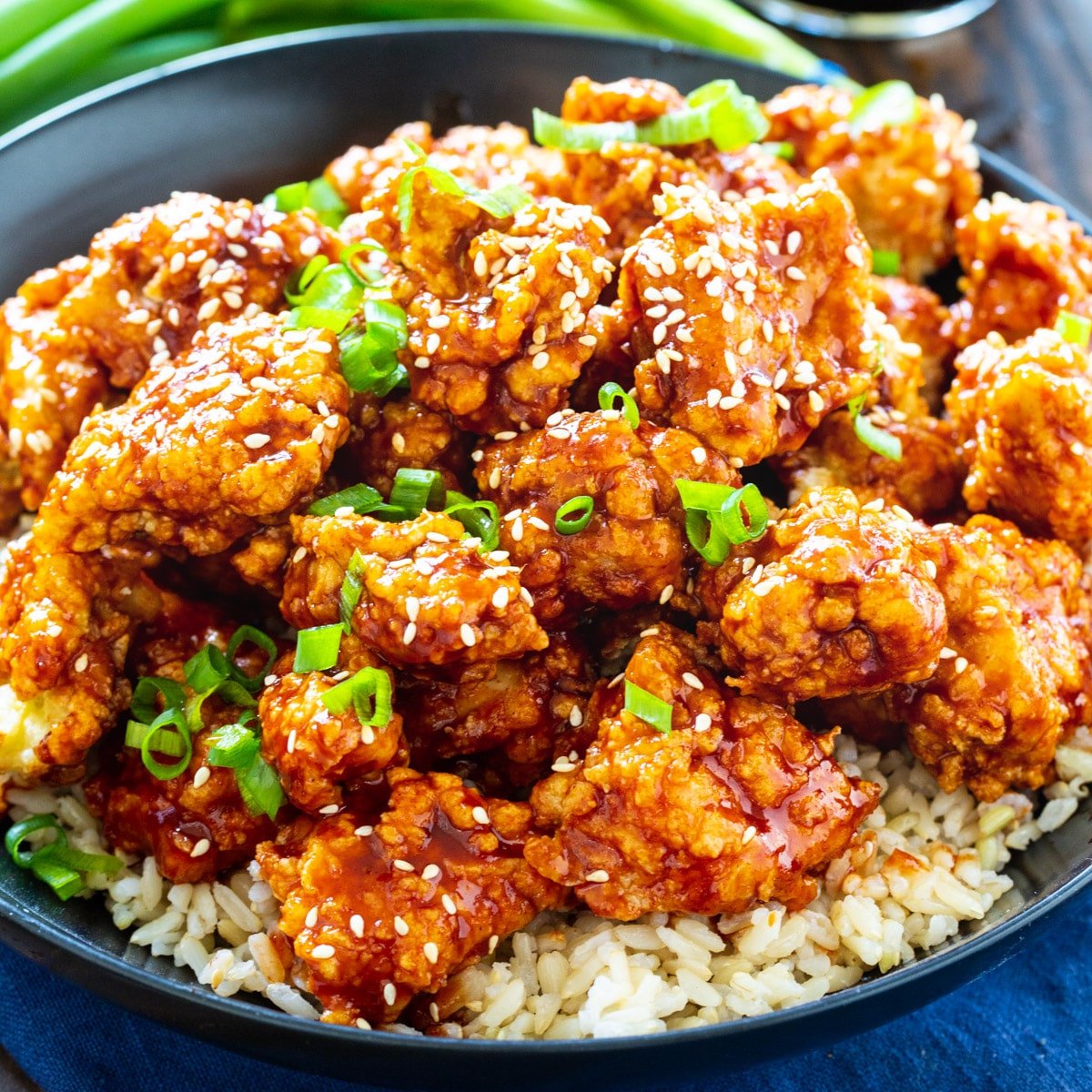 Korean Fried Chicken topped with sesame seeds and green onions.