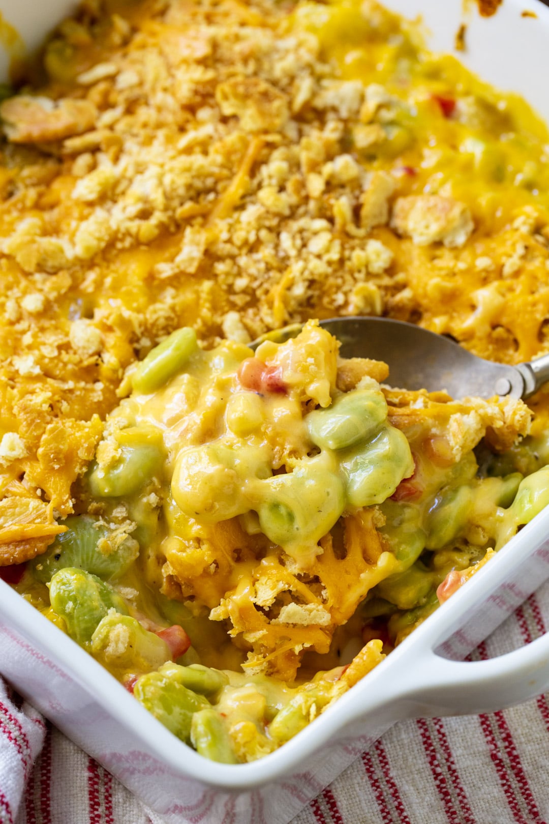 Spoon scooping casserole out of baking dish.