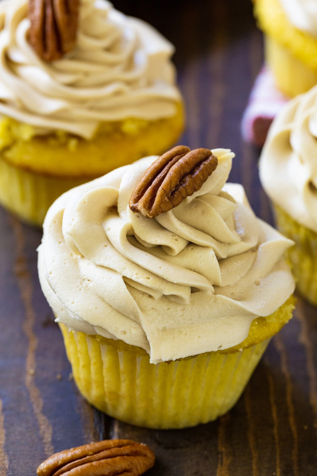 Pecan Pie Cupcakes topped with brown sugar frosting and a pecan.