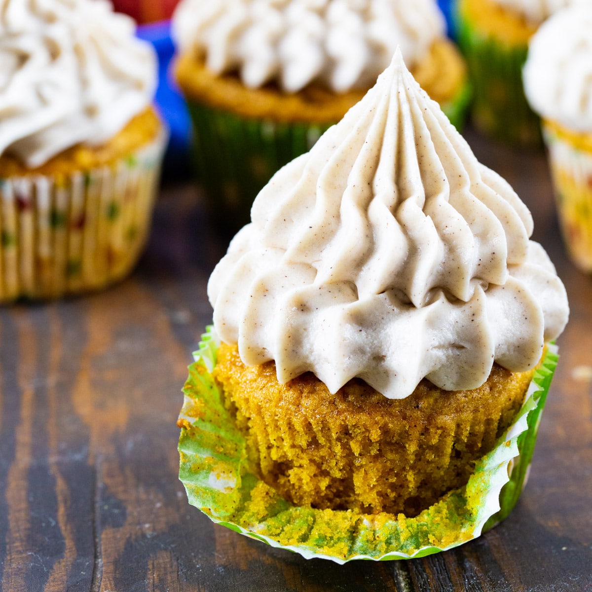 Pumpkin Cupcakes with Cinnamon Cream Cheese Frosting with wrapper pulled down.