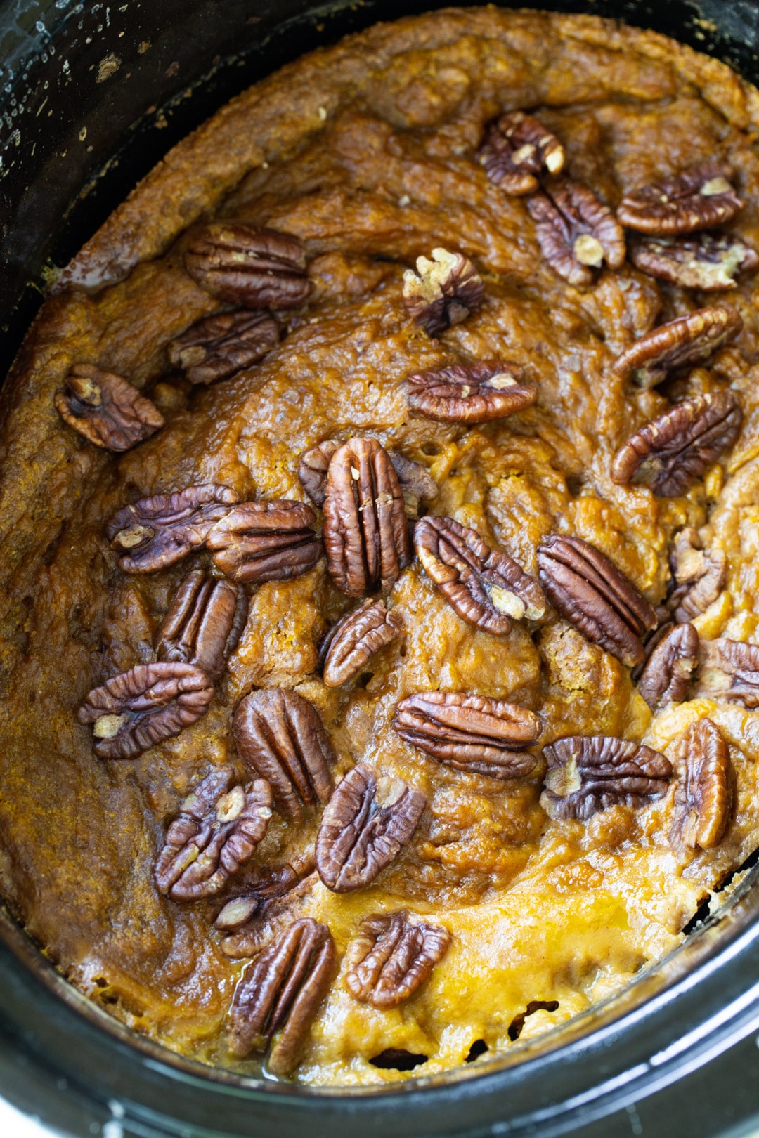 Slow Cooker Pumpkin Cake topped with pecans in slow cooker.