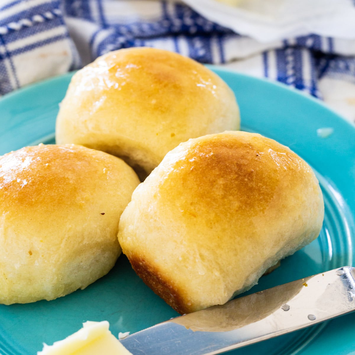Three Buttery Pan Rolls on a blue plate.