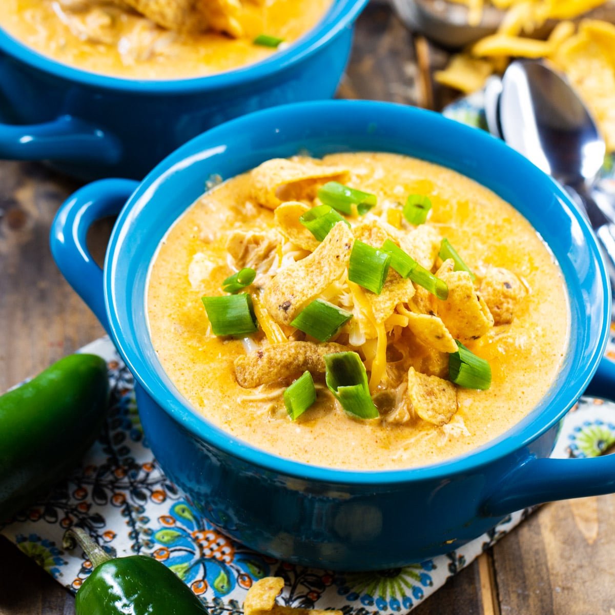 Slow Cooker White Chicken Chili topped with frito chips in a blue bowl.