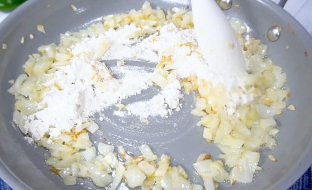 Sprinkling flour over onions.