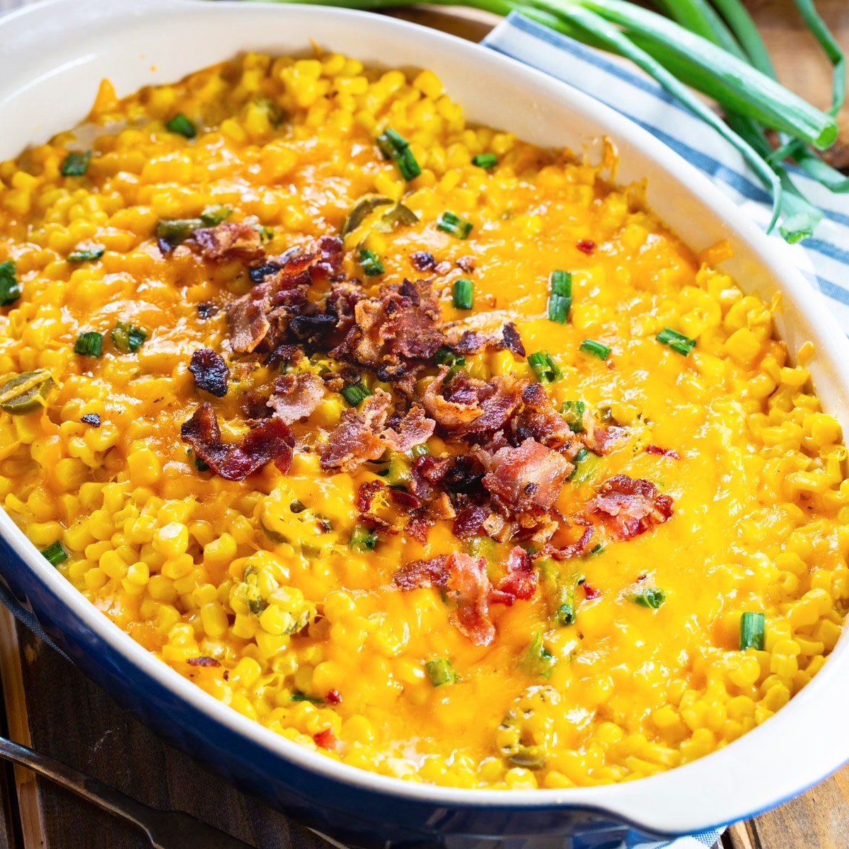 Cheddar Corn Casserole topped with bacon in casserole dish.