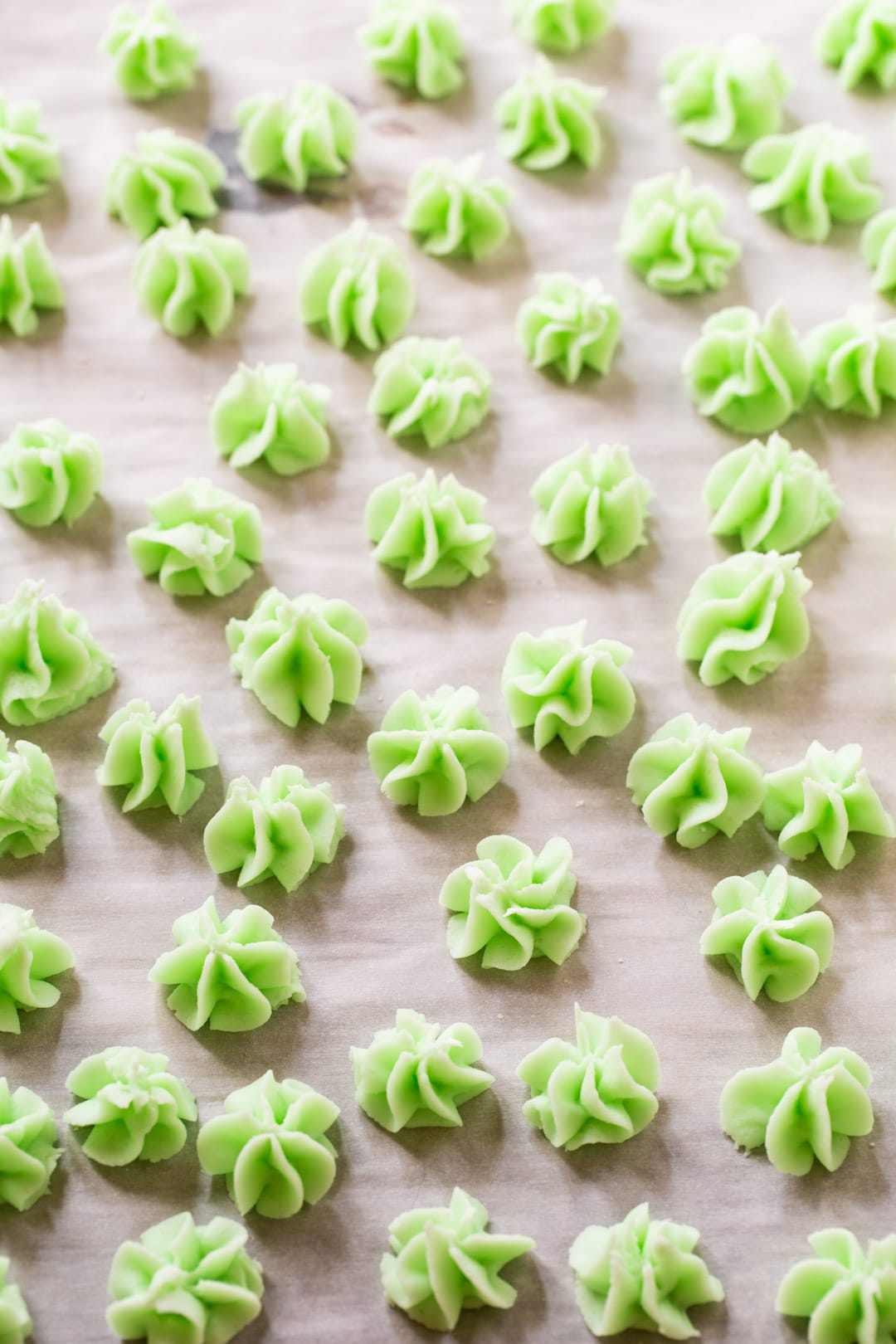 Cream Cheese Mints spread out on parchment paper.