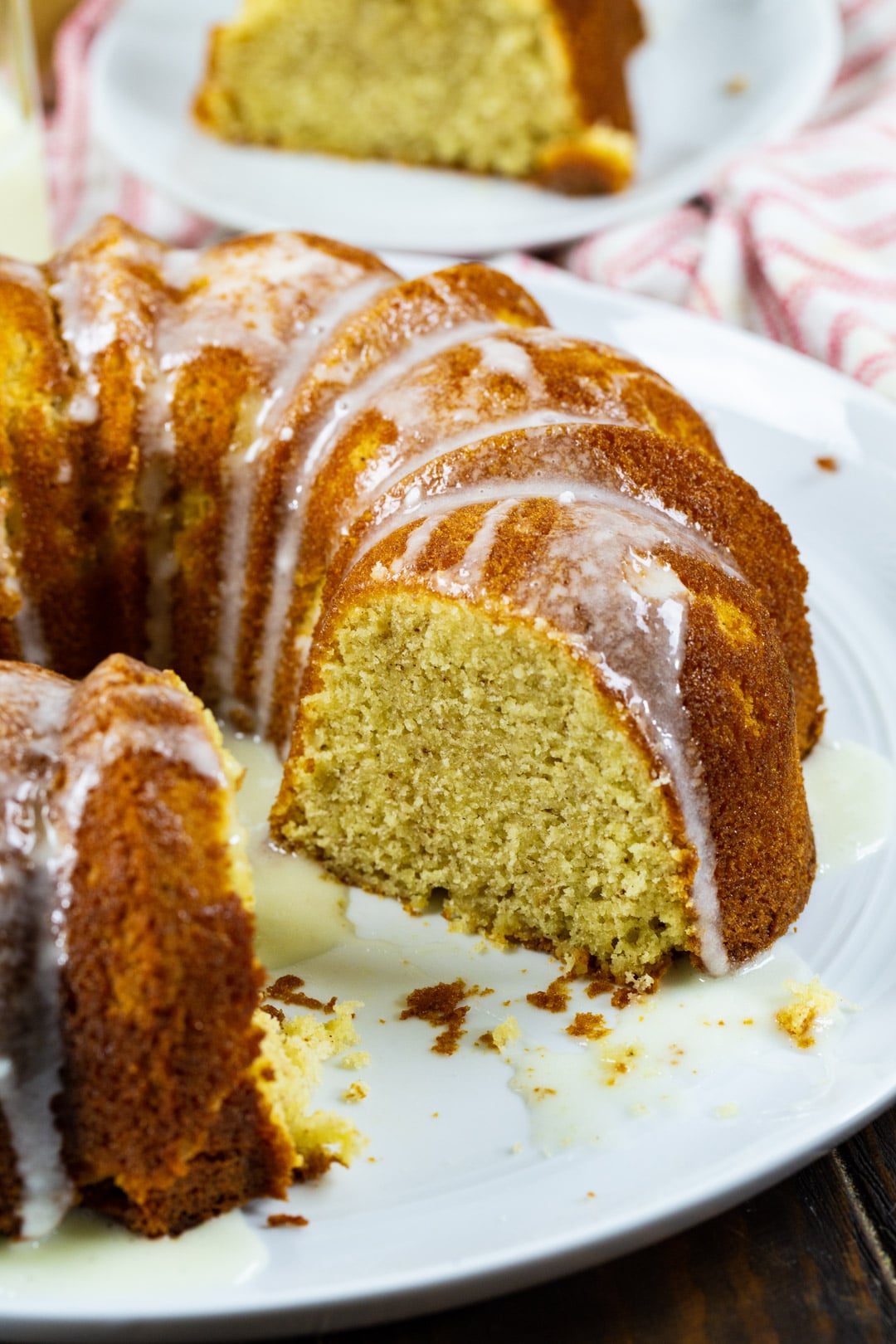 Whole pound cake with a slice cut out on a serving plate.