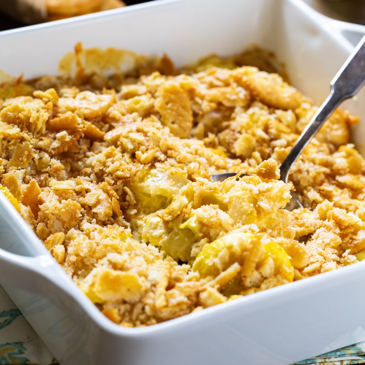 Yellow Squash Casserole in white square baking dish.