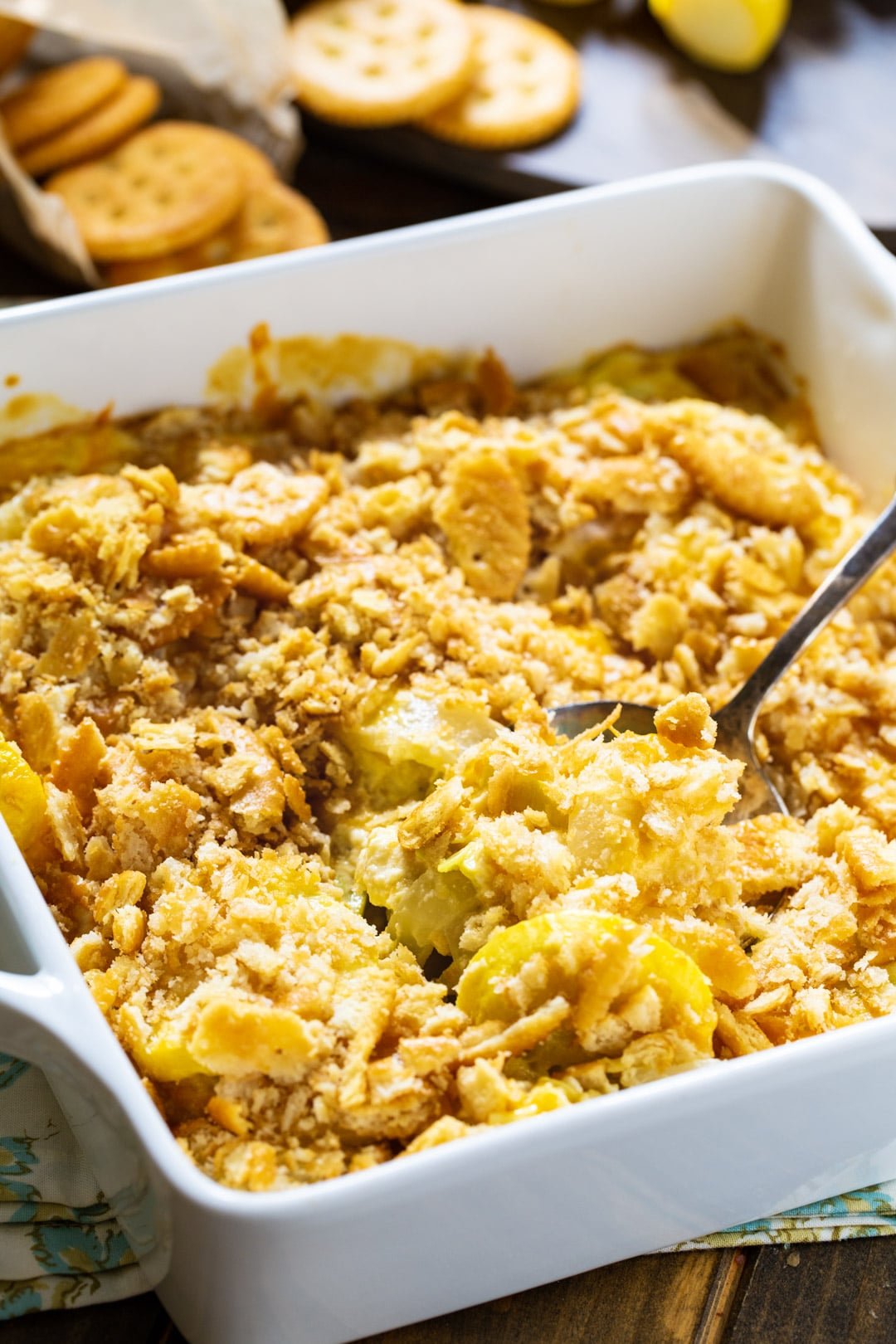 Spoon scooping squash casserole out of baking dish.