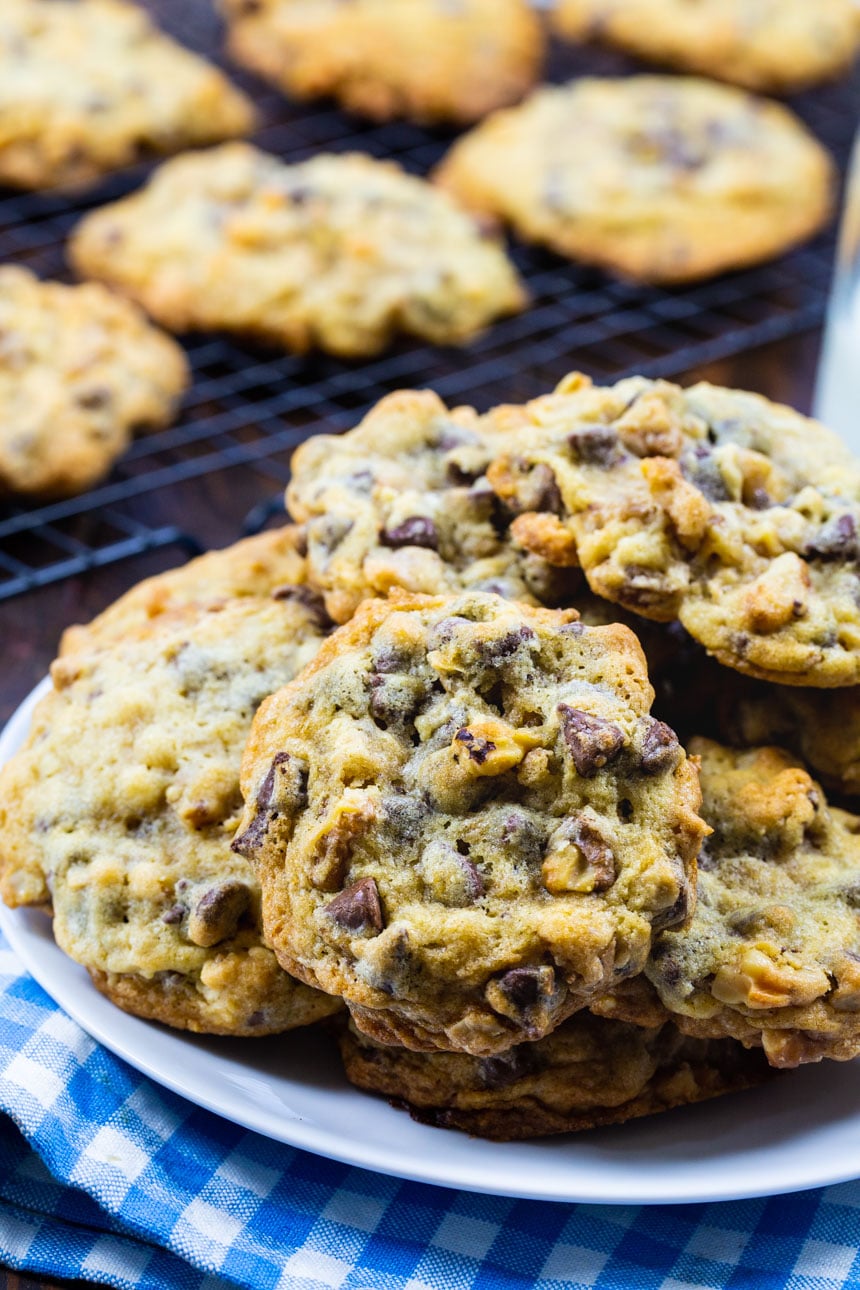 Cookies on a plate with cookies on wire rack in background.