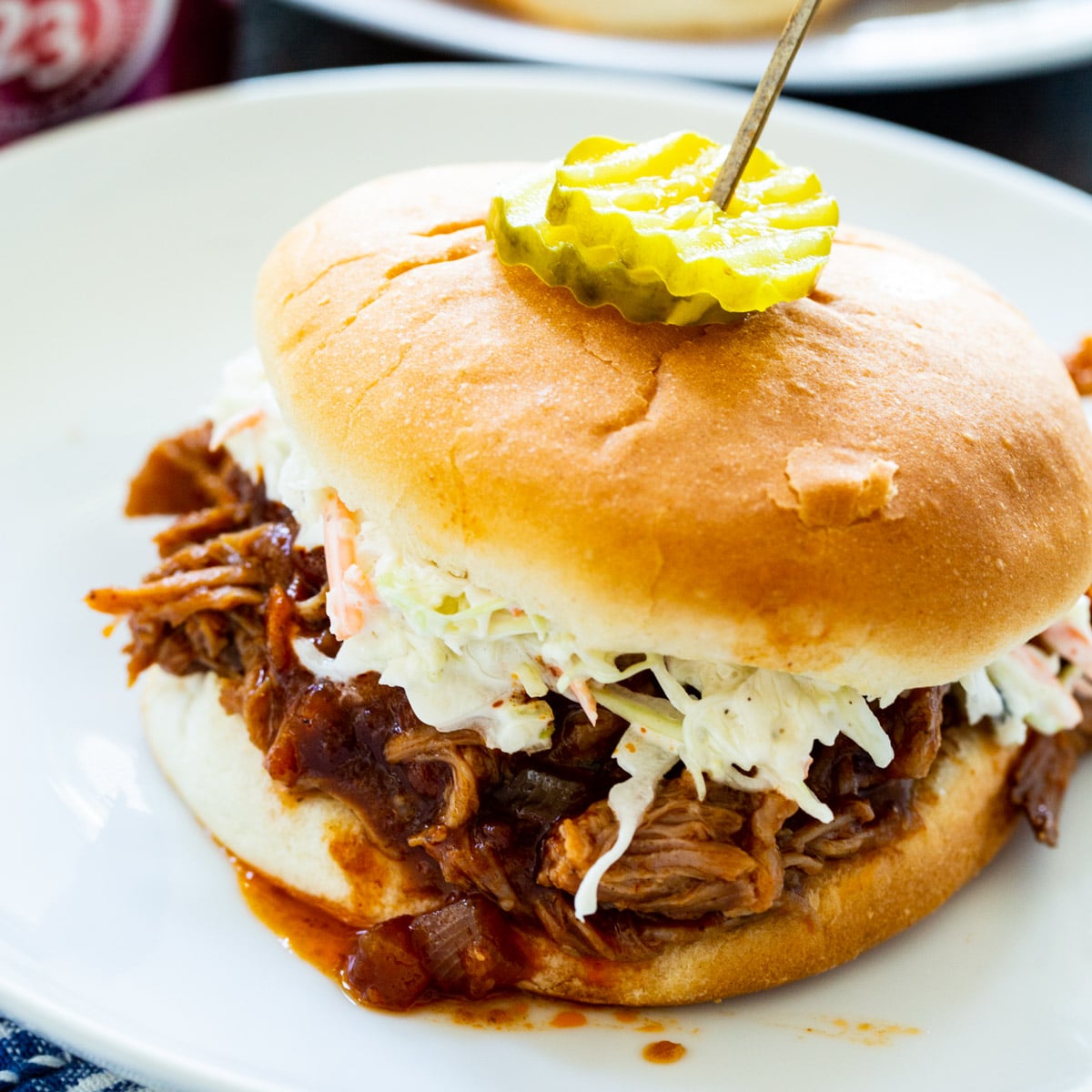 Slow Cooker Dr. Pepper Pulled Pork on a bun with coleslaw.
