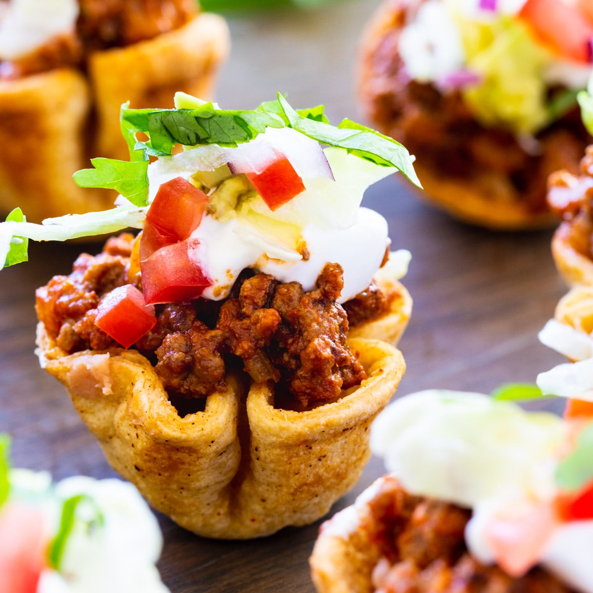 Mini Taco Bites arranged on a wooden board.