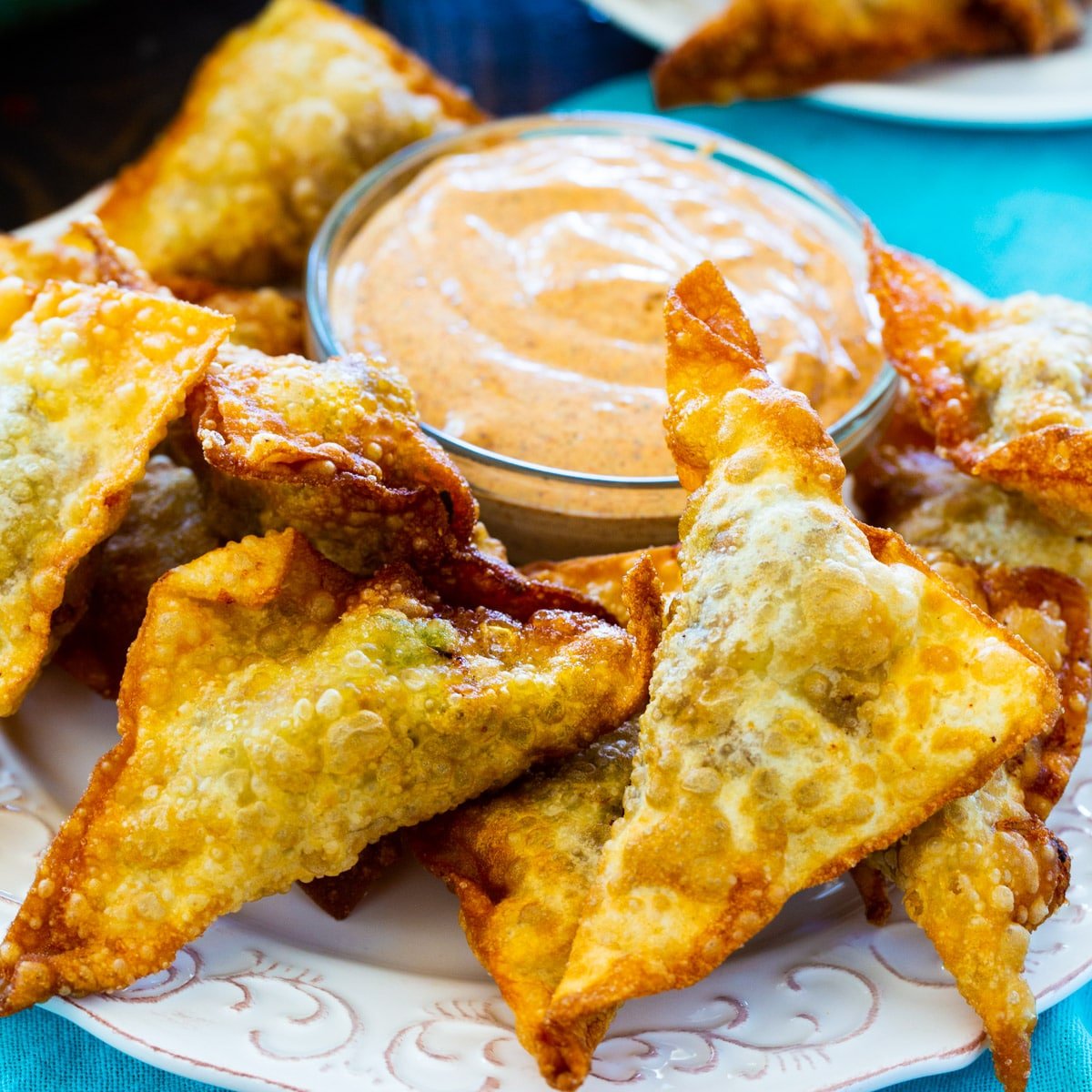 Taco Wontons on a plate with bowl of dipping sauce.