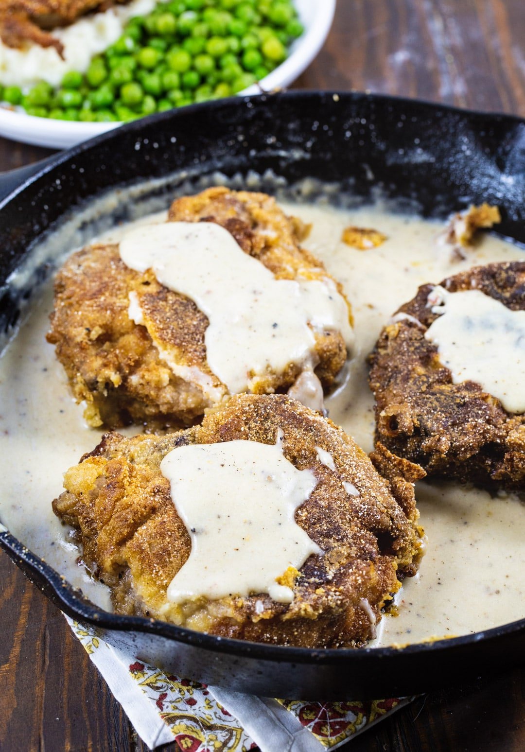 Southern Fried Pork Chops with White Gravy in cast iron pan.