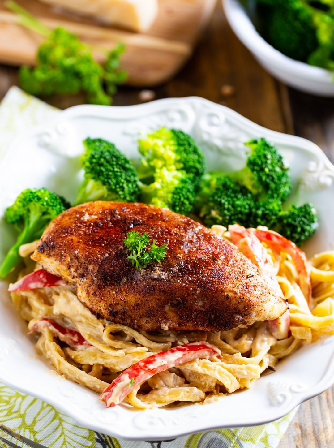 Blackened Chicken Fettuccine in a bowl with steamed broccoli.