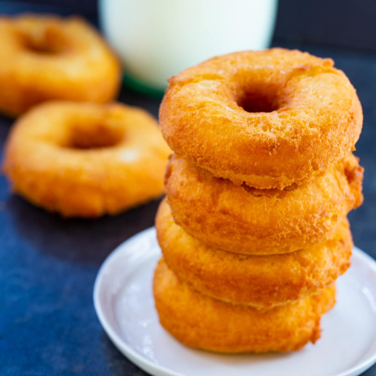 Four Old-Fashioned Buttermilk Doughnuts stacked on a small plate.