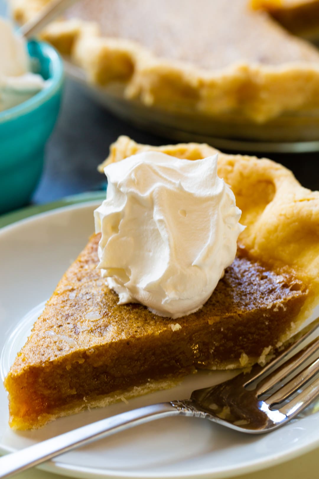 Slice of Caramel Chess Pie topped with whipped cream.