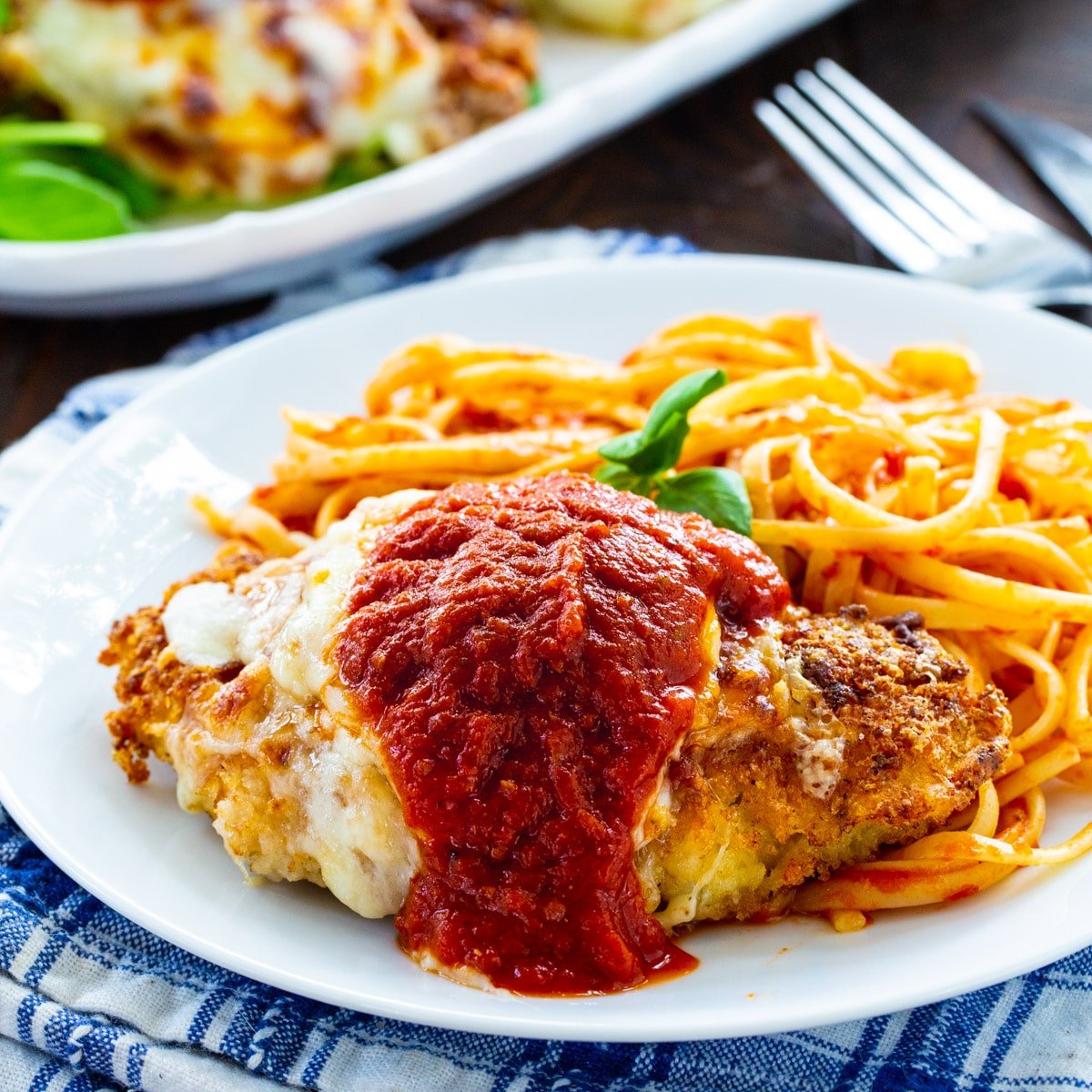 Chicken Parmesan on a plate with pasta.