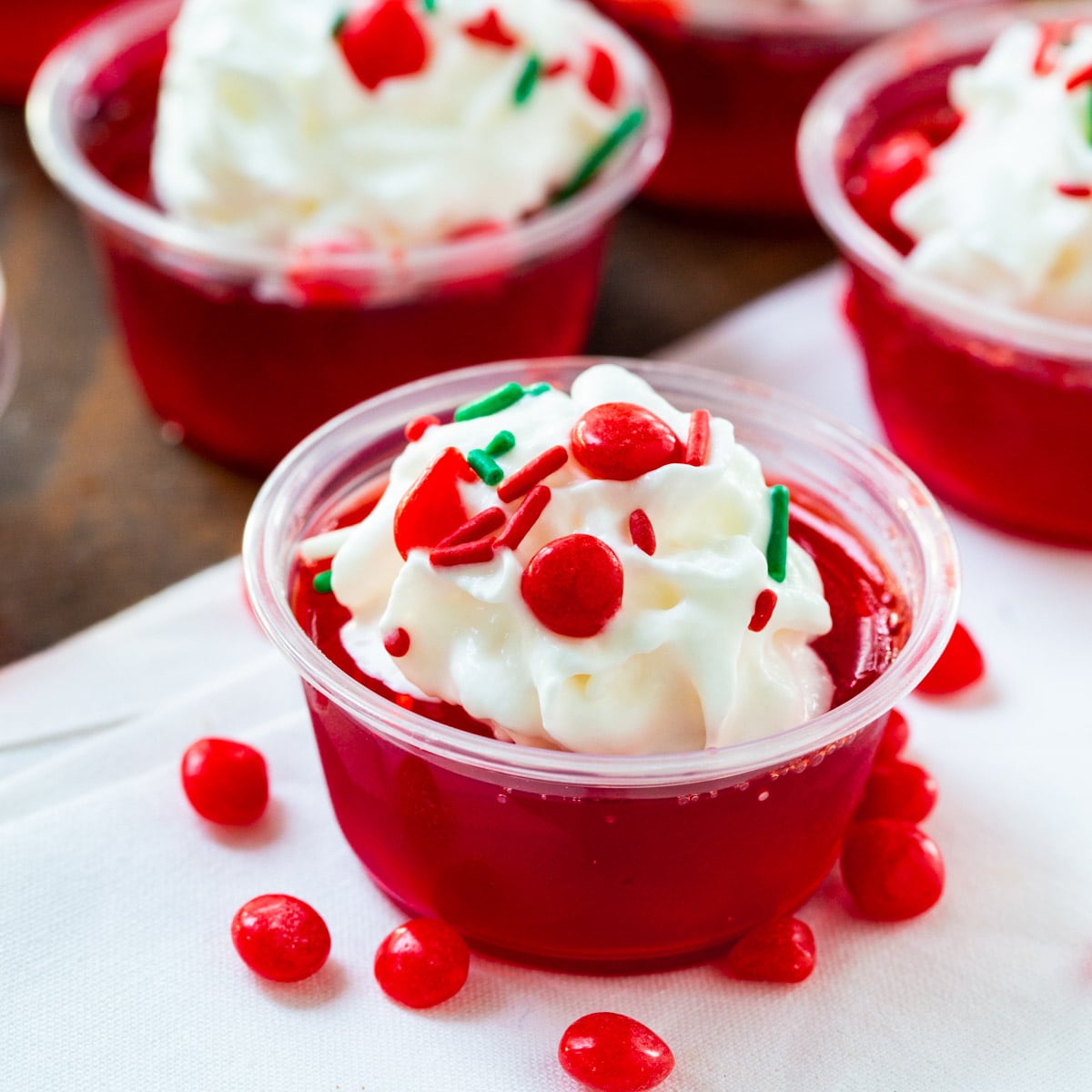 Fireball Jello Shots topped with whipped cream and sprinkles.