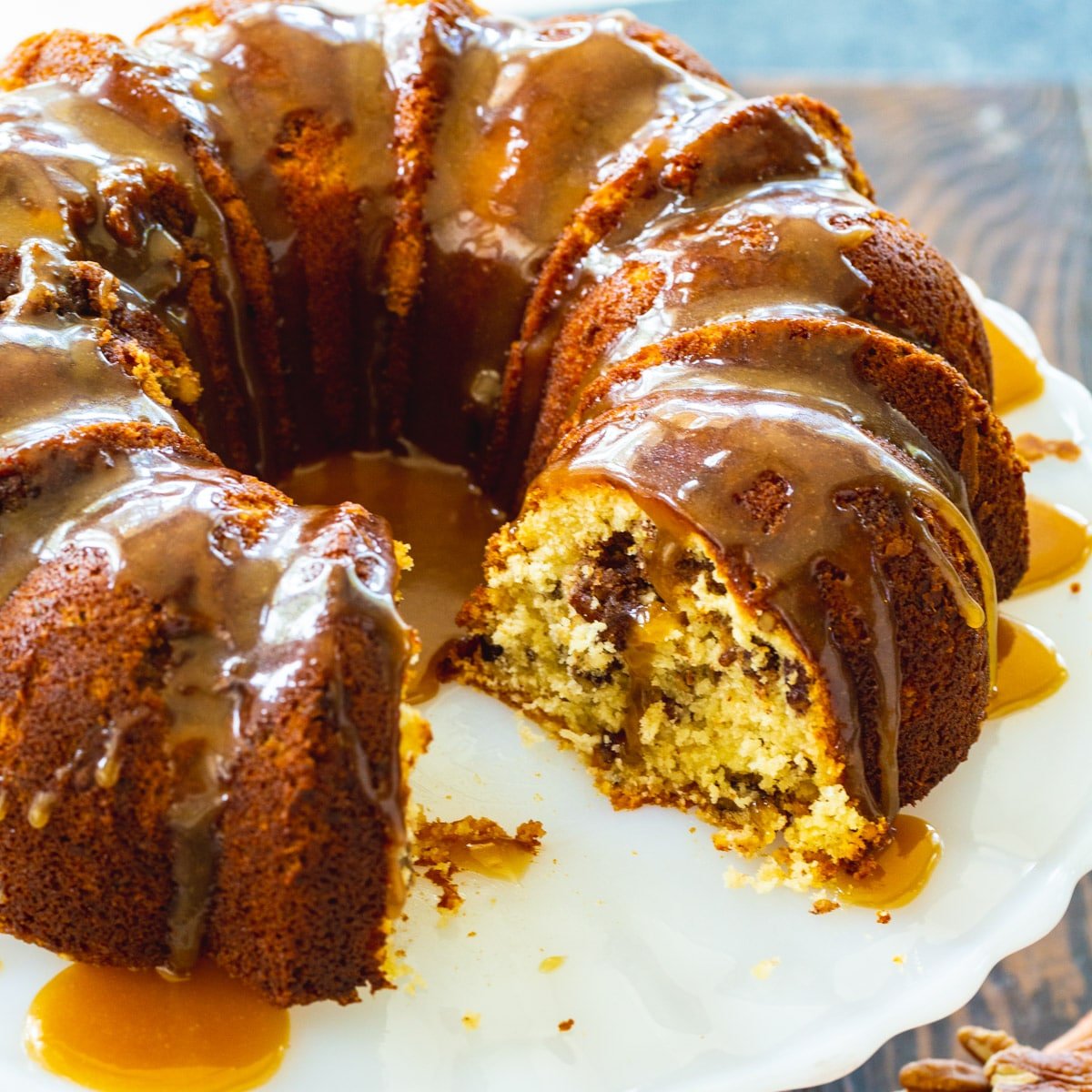 Pecan Pie Bundt Cake on serving platter with slices cut out.