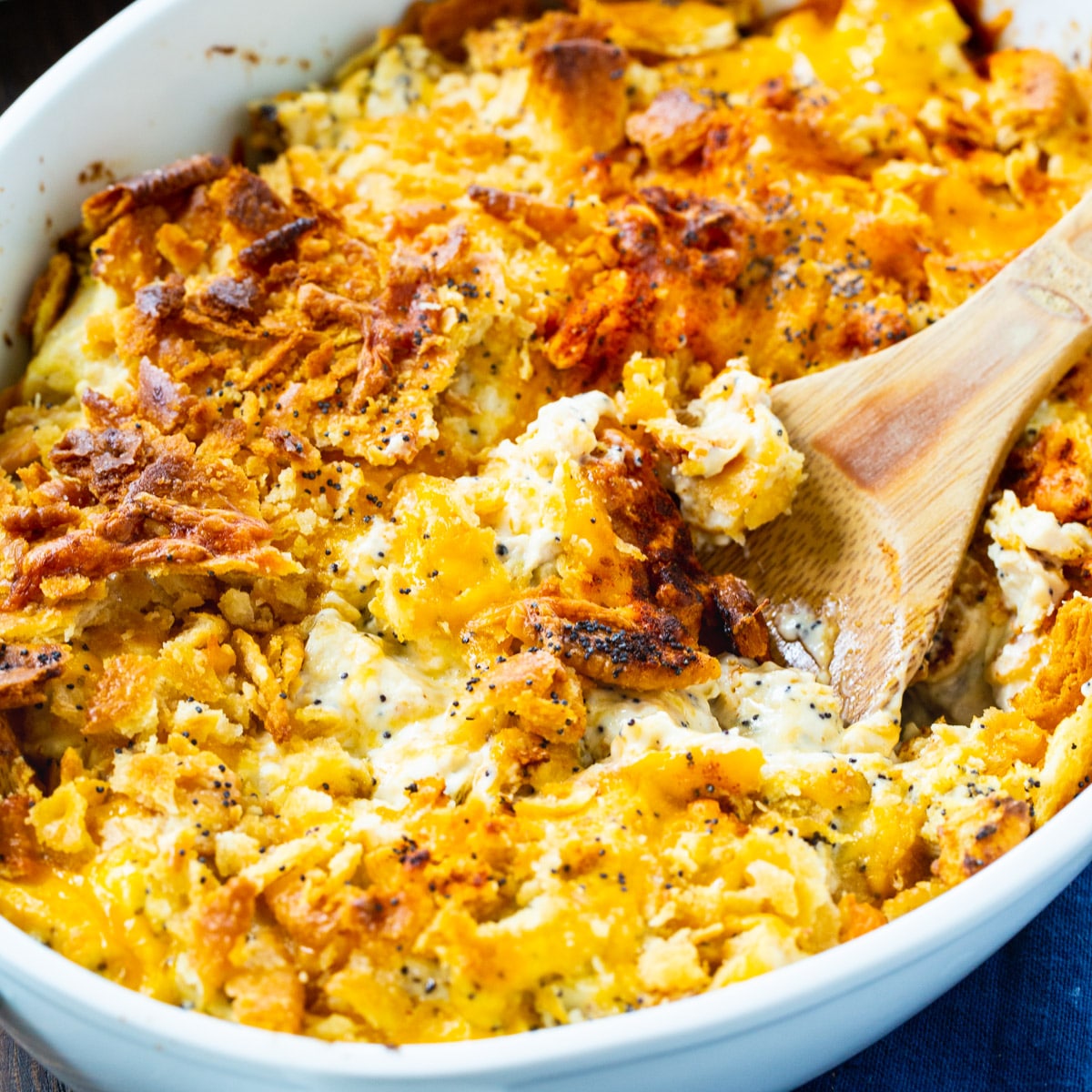 Wooden spoon scooping Poppy Seed Chicken Casserole.